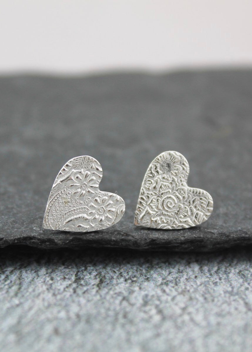 Lucy Kemp lace textured heart studs photographed against slate background