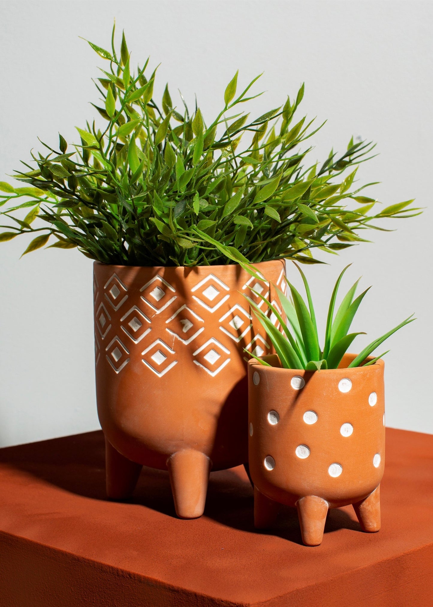 Terracota planter with legs and geometric white detailing 