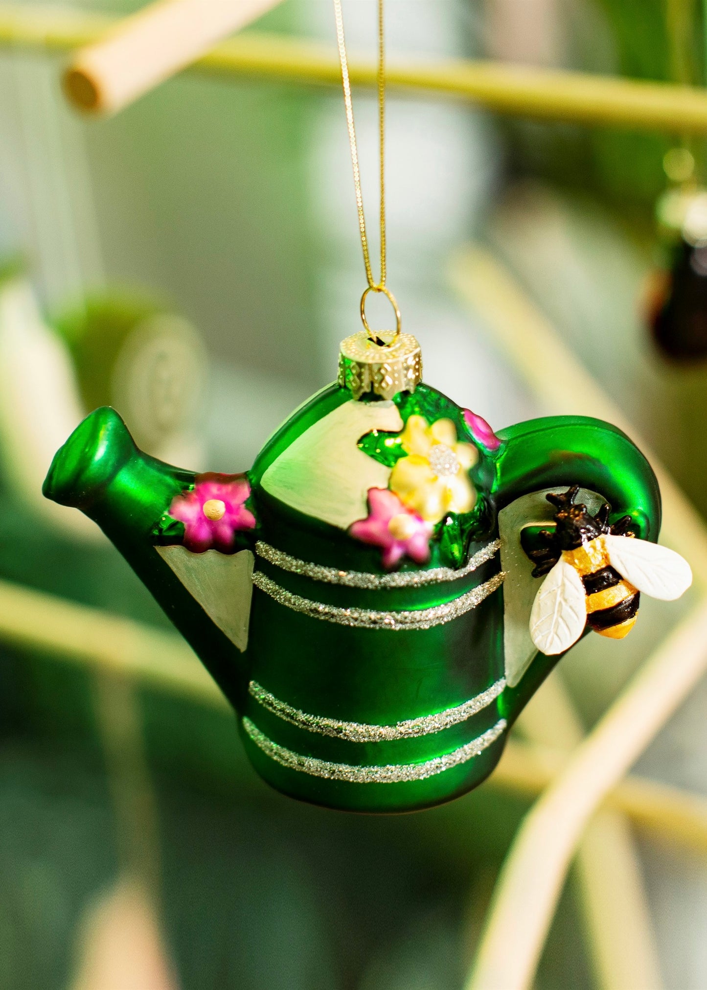 Green watering can with flowers and bumblebee 