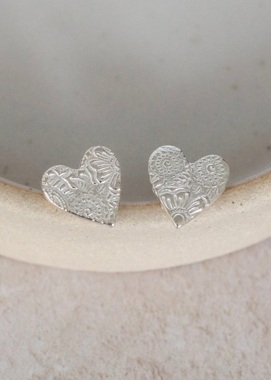 handmade silver heart shaped studs from Lucy Kemp. with a lace imprint texture to the surface, aprox 12mm in size