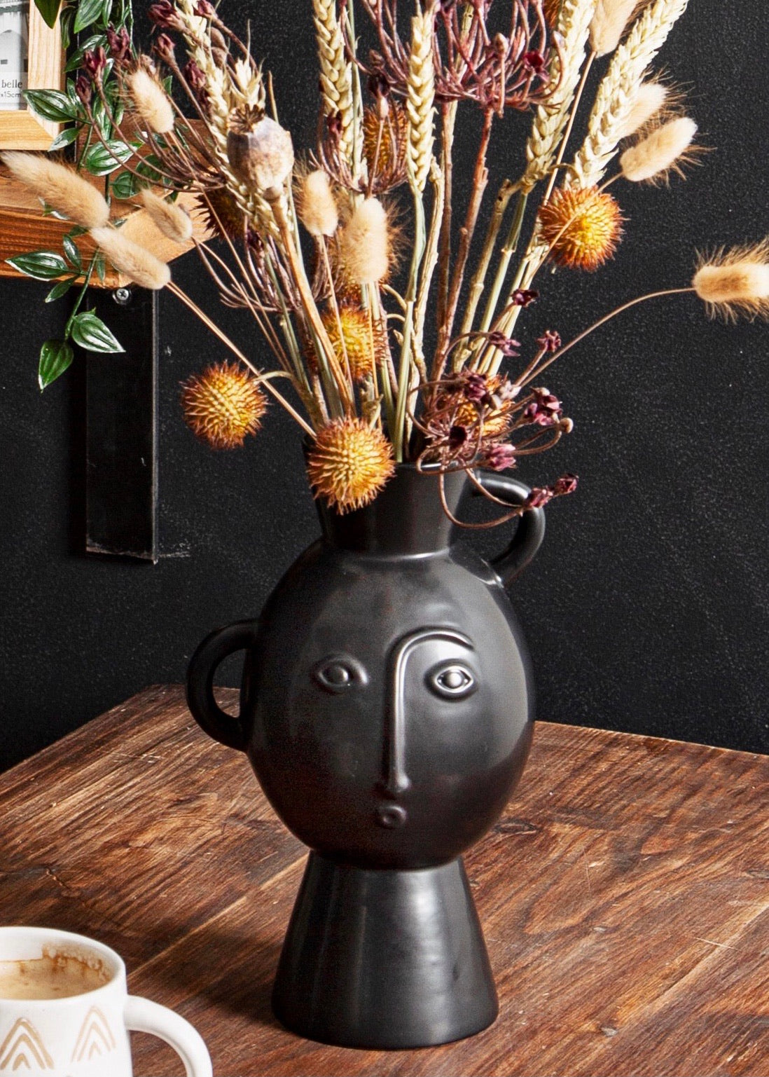 Matt black vase with handles and face details 