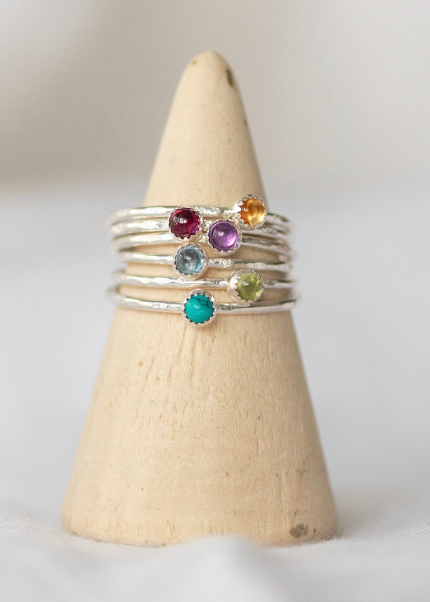 Lucy Kemp semi precious stone stacker rings, layered up on a ring stand