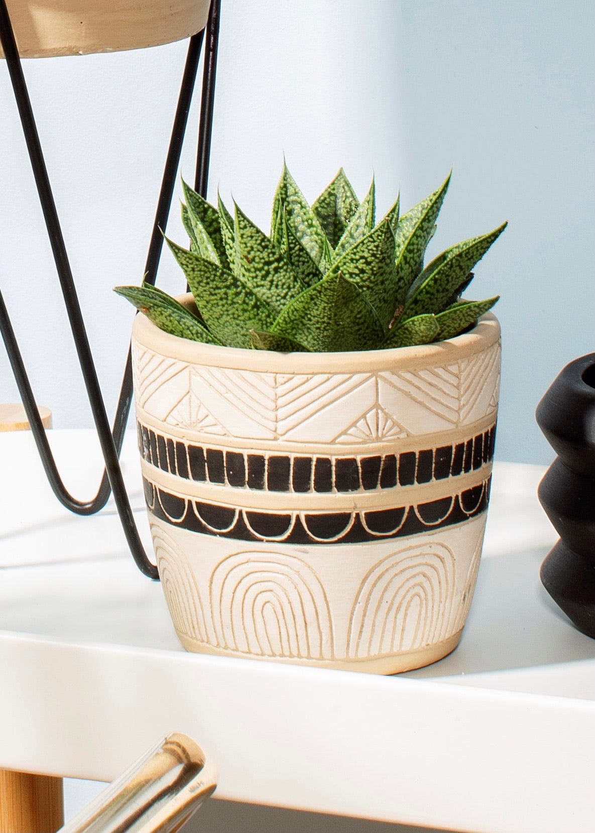 White and black planter with carved out details 